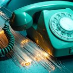Vintage rotary telephone with glowing fiber optic cables representing modern VoIP and Asterisk telephony